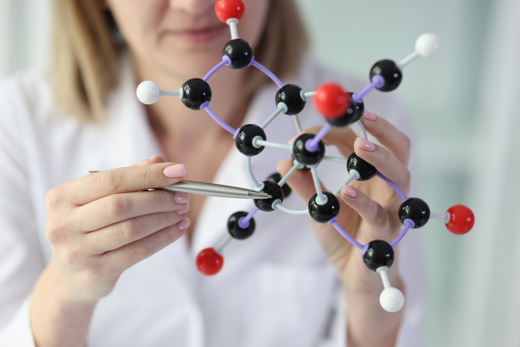 female-scientist-holds-model-molecular-structure-points-one-molecule-closeup.jpg